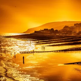 A rare but spectacular shot of the seafront in Eastbourne looking towards the Martello tower and the cliffs behind. The whole photo is bathed in orange light (or a very good filter).