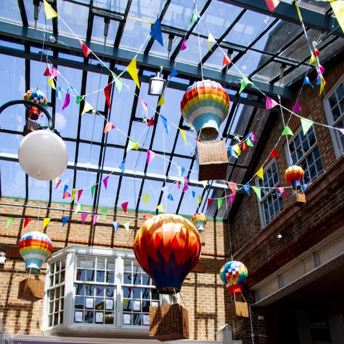 A photo of the covered area at the Enterprise Shopping Centre. There are model hot-air balloons hanging from the ceiling.