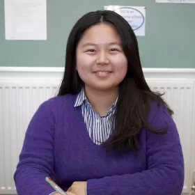 A lovely photo of Seonyeong Hong from the Republic of Korea, smiling for the camera during her English class in ELC Eastbourne. She's wearing a knitted purple jumper.